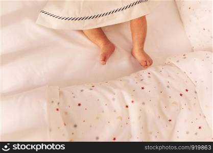 baby's legs on the bed. top view. little baby legs in dress.. baby's legs on the bed. little baby legs in dress. top view