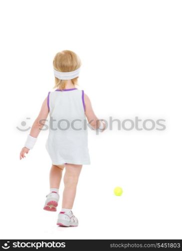 Baby running for tennis ball . rear view