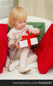 Baby sitting on chair and open Christmas gift box