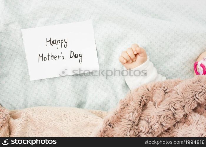 baby sleeping bed near happy mothers day inscription