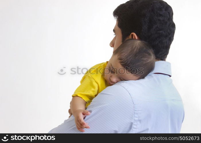 Baby sleeping in fathers arms