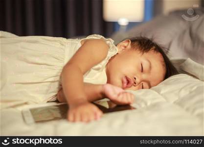baby sleeping on bed after playing digital tablet