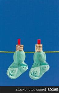 baby socks on clothesline with dollar bills. blue skies.