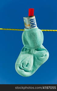 baby socks on clothesline with swiss francs. blue skies.