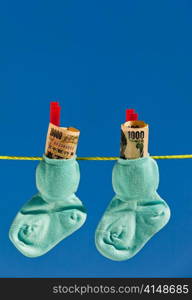 baby socks on clothesline with yen banknotes from japan.