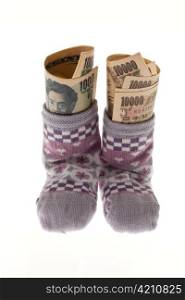 baby socks on clothesline with yen banknotes from japan.