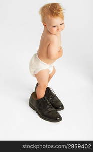 Baby Standing in Man&acute;s Shoes