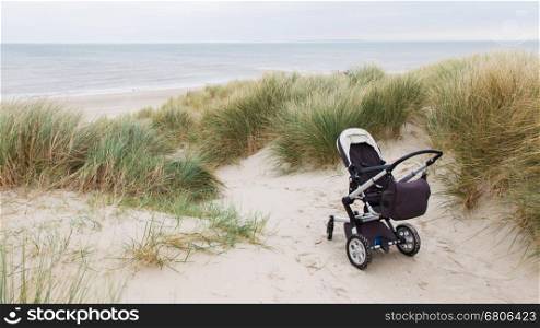 Baby stroller standing at a beach in the Netherlands