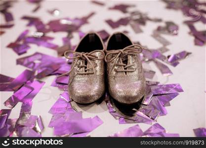 Baby stylish shoes on white background with colorful confetti an copyspace. place for inscription. Baby stylish shoes on white background with colorful confetti an copyspace. place for inscription.