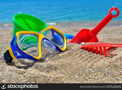 Baby Toys on the beach sand against the blue sea