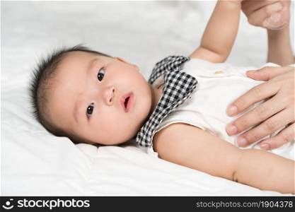 baby with mother hand on a bed at home