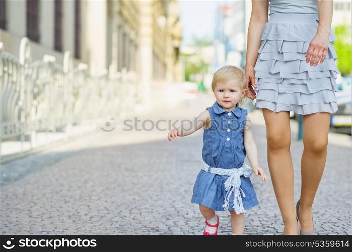 Baby with mother walking in city