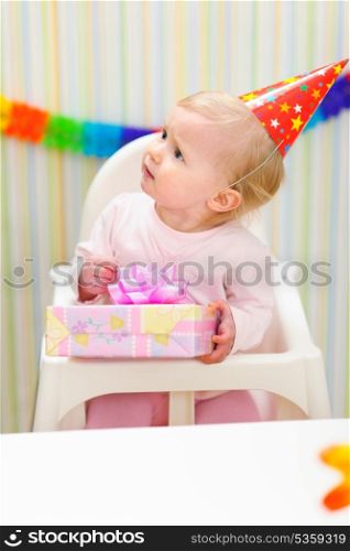 Baby with present looking in corner