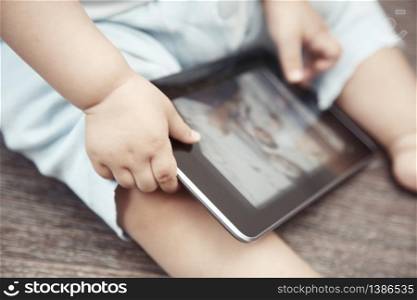 Baby with tablet computer. Close-up photo of the hands