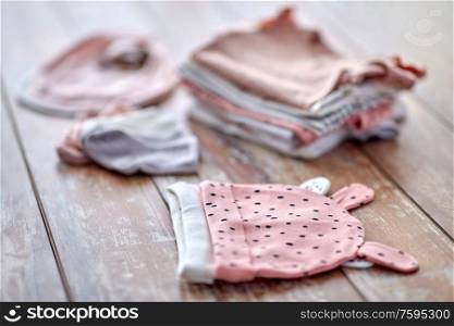 babyhood and clothing concept - close up of baby clothes on wooden table. close up of baby clothes on wooden table