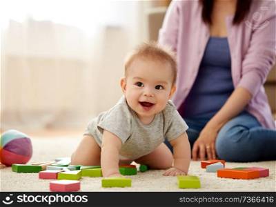 babyhood, childhood and family concept - happy asian baby boy with toy blocks on carpet at home. happy baby boy with toy blocks on carpet at home