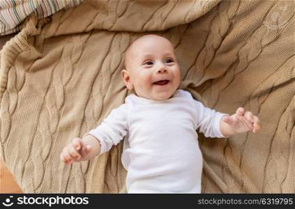 babyhood, childhood and people concept - sweet little baby boy lying on knitted blanket. sweet little baby boy lying on knitted blanket