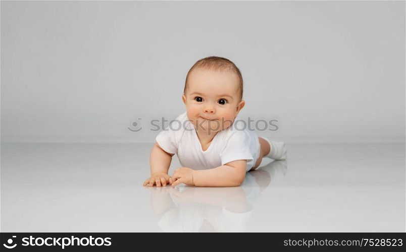 babyhood, childhood and people concept - sweet little baby lying on floor. sweet little baby lying on floor