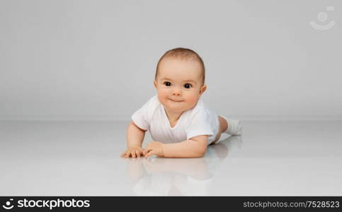 babyhood, childhood and people concept - sweet little baby lying on floor. sweet little baby lying on floor