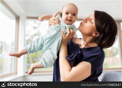 babyhood, motherhood and people concept - middle-aged mother holding baby daughter at home. middle-aged mother holding baby daughter at home