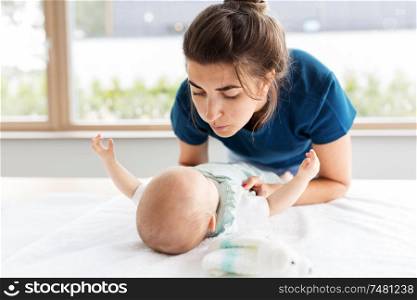 babyhood, motherhood and people concept - mother with baby daughter at home. mother with baby daughter at home