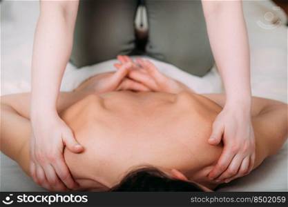 Back massage in a massage salon, woman having a relaxing back massage.