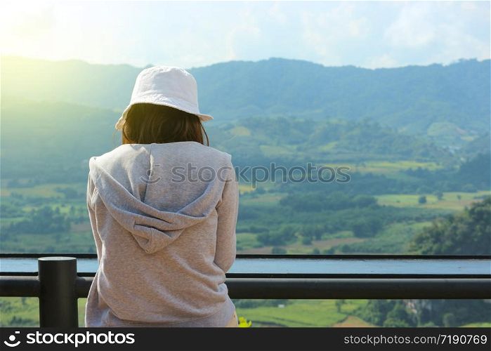 Back of asian girl sitting and watching a natural view.