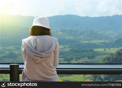Back of asian girl sitting and watching a natural view.