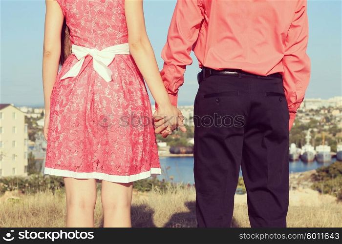 Back of couple holding hands