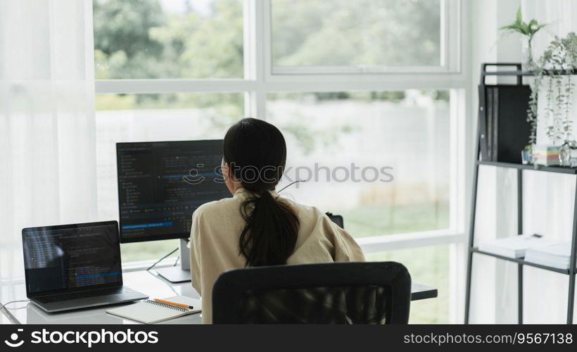 Back of developer programmer programming code to developing web and application in software office.