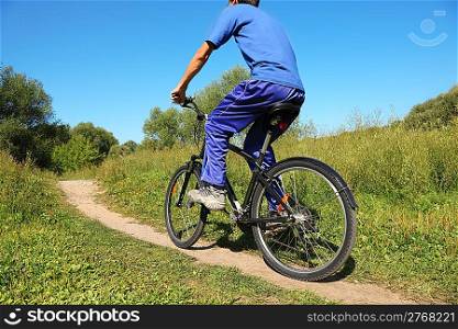 back of man wearing sporty clothers. one man is riding on bicycle