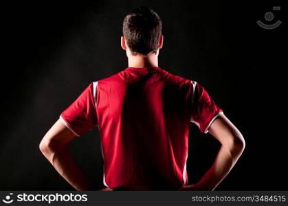 back of soccer player on black background