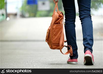 Back of student girl holding school bag while walking in school campus background, education, back to school concept