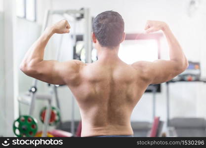 Back of view Asian men doing bodybuilder Rear Double Biceps pose in gym so strong and powerful,Bodybuilder Concept