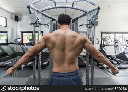Back of view Asian men workout with cable crossover machine Concentration muscle on back for bodybuilding feeling so strong and powerful,Bodybuilder Concept