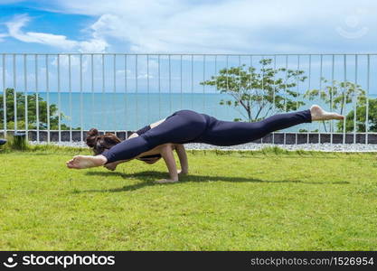 Back of view Asian woman relaxing in yoga Shoulder Opening Pose with beautiful sea view,Feeling relax and comfortable,Healthy Concept