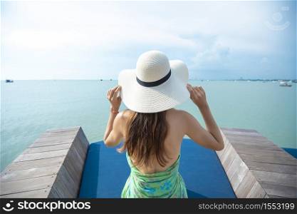 Back of woman in white hat on the beach