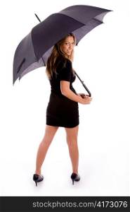 back pose of smiling female carrying umbrella on an isolated white background