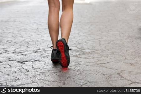 back shot of young lady with fitness shoes in act to walking ,running on a broken fashion road