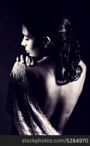 Back side of a gentle dreamy bride in the morning, wearing lace dressing gown with open back, black and white photo of a romantic bridal look