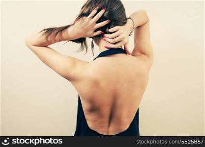 Back side of blonde women with arms on head