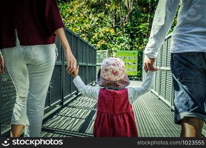 Back side of Happy asian family father mother and daughter walking on the canopy walkway, movement walking, family and travel concept