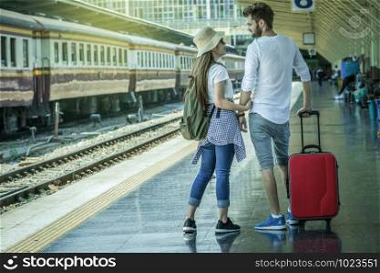 Back side of Multiethnic Travellers are looking the destination at the train station, Travel and transportation concept