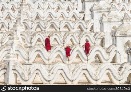 Back side of three young monk are Climbing up on the Mya Thein Tan Pagoda at bagan, mandalay, myanmar