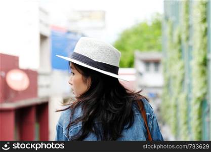 Back side of woman traveler standing with city outdoors background, casual lifesyle, travel blogger