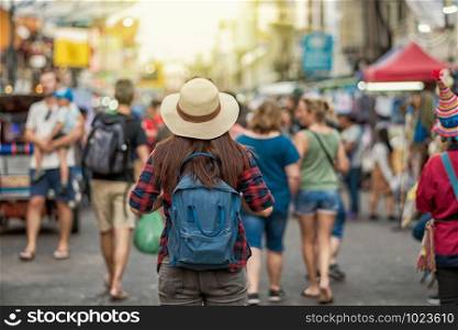 Back side of Young Asian traveling women walking and looking in Khaosan Road walking street in evening at Bangkok, Thailand, traveler and tourist concept