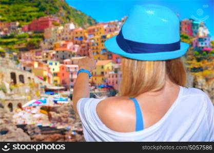 Back side of young girl enjoying beautiful cityscape, Europe, Italy, Cinque Terre, traditional old architecture, buildings painted in different colours