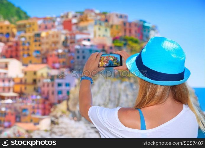 Back side of young woman making picture of beautiful colorful old italian buildings, happy travel to Europe, summer vacation concept