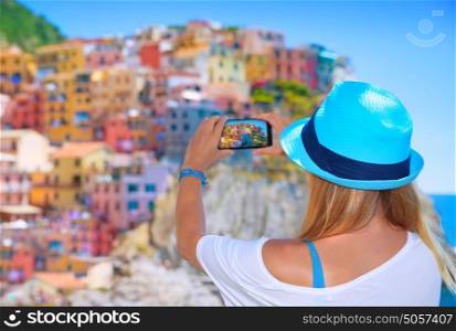 Back side of young woman making picture of beautiful colorful old italian buildings, happy travel to Europe, summer vacation concept