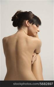 back side portrait of a lovely young naked woman , in sweet pose . she has natiral skin and retouch